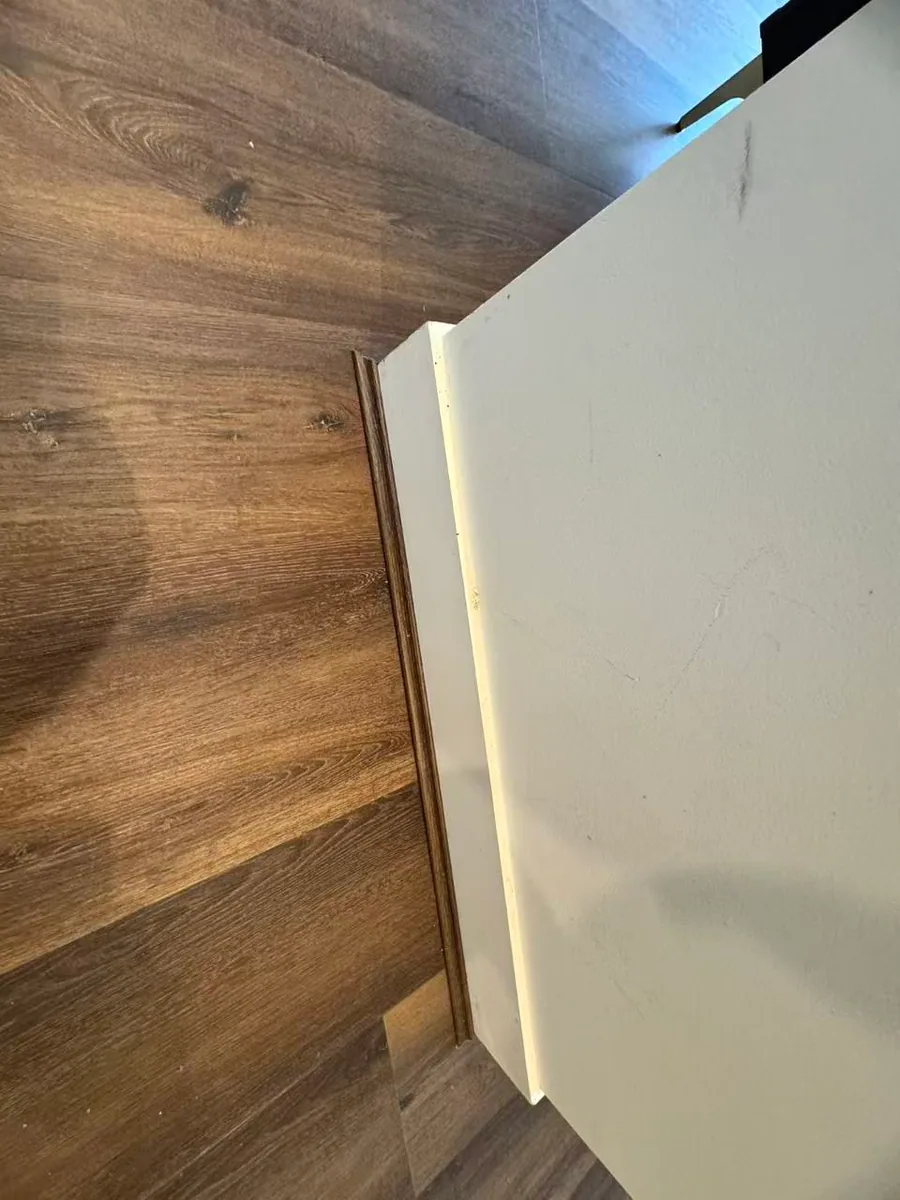 Owner-supplied close photo of flooring beside an interior wall